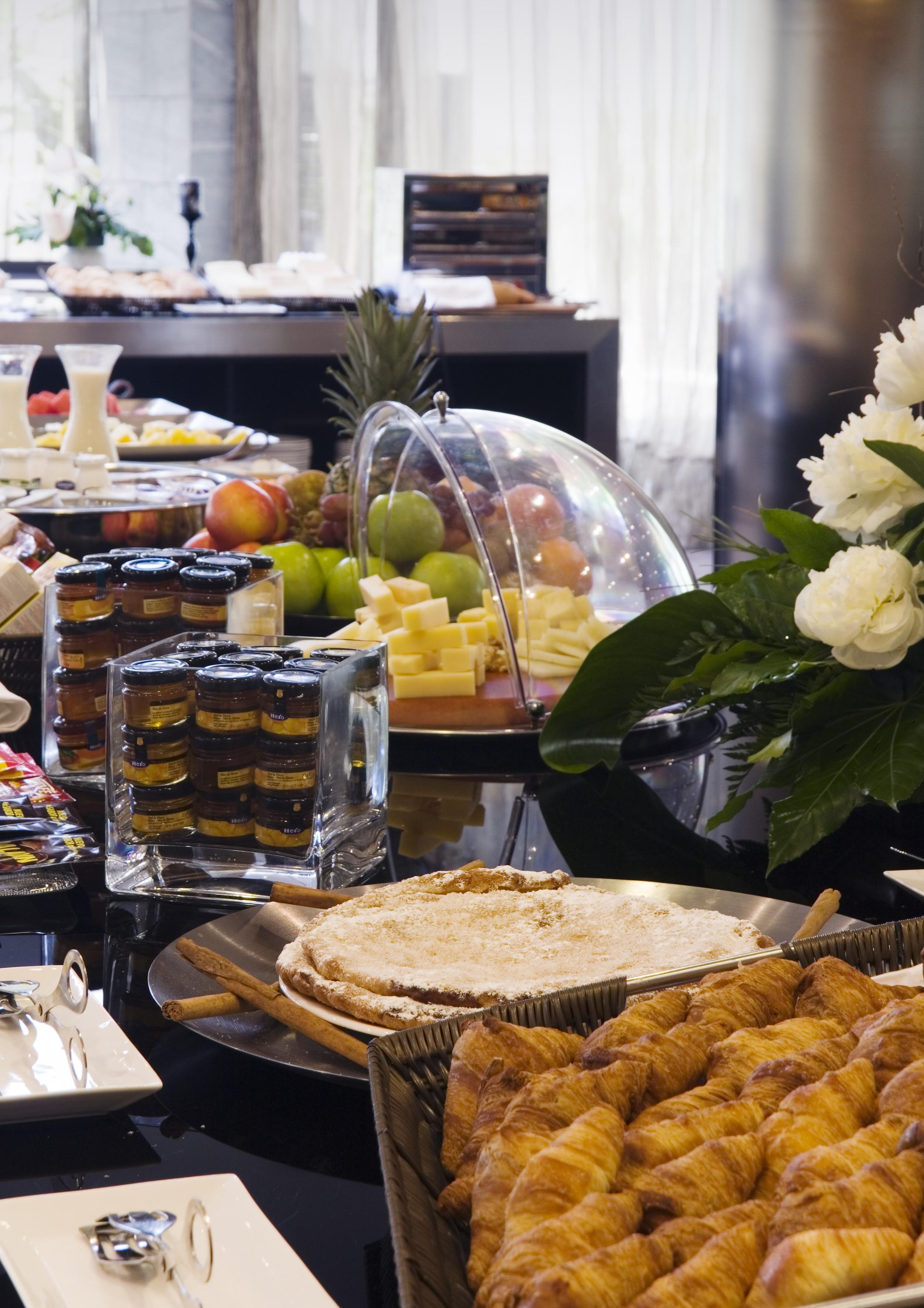 Eurostars Palace Κόρδοβα Εξωτερικό φωτογραφία The photo shows a buffet-style arrangement with a variety of food items. There are fruits such as apples and grapes displayed prominently, along with a selection of cheeses presented on a wooden platter. A glass dome covers some of the items, possibl
