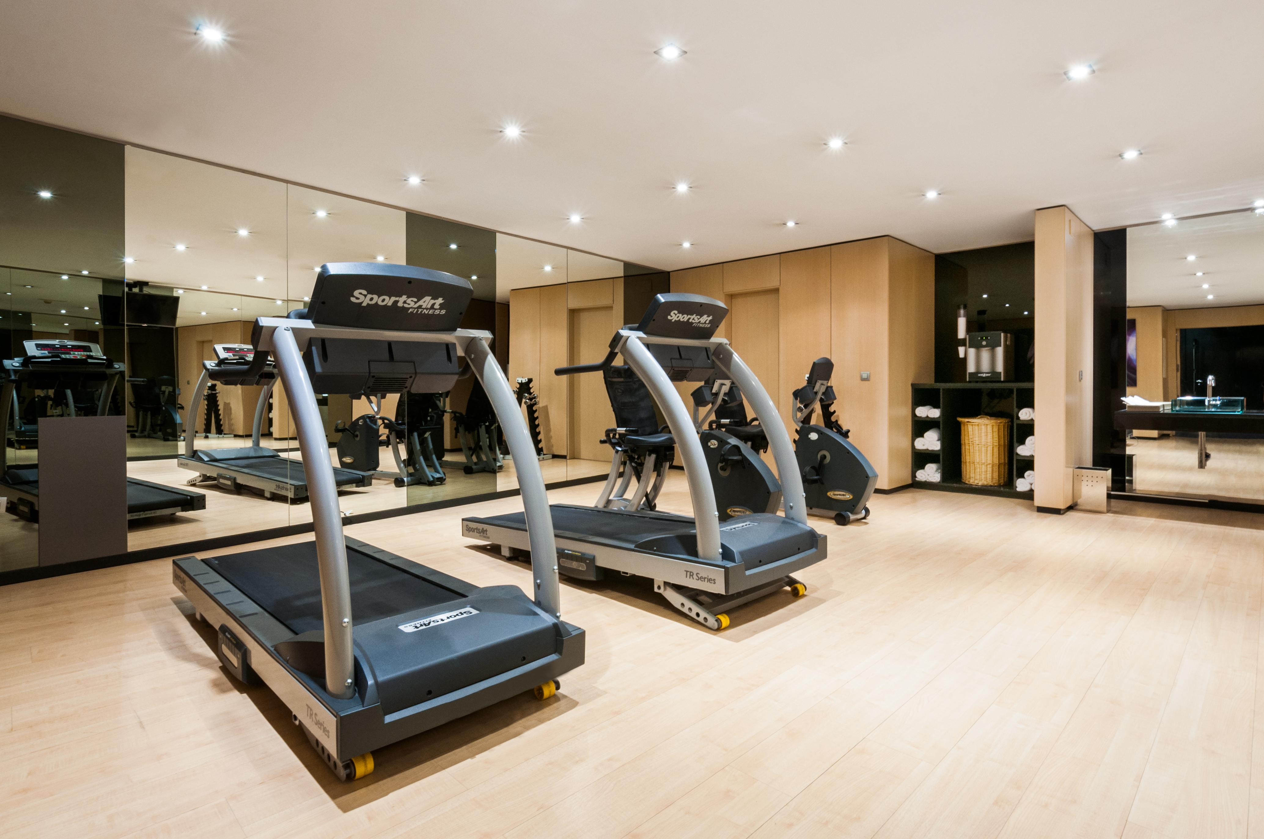 Eurostars Palace Κόρδοβα Εξωτερικό φωτογραφία The photo shows a modern gym or fitness area featuring two treadmills. The equipment is well-maintained and positioned on a light wooden floor. There are mirrors on the wall reflecting the workout area, which adds to the spacious feel. The overall se