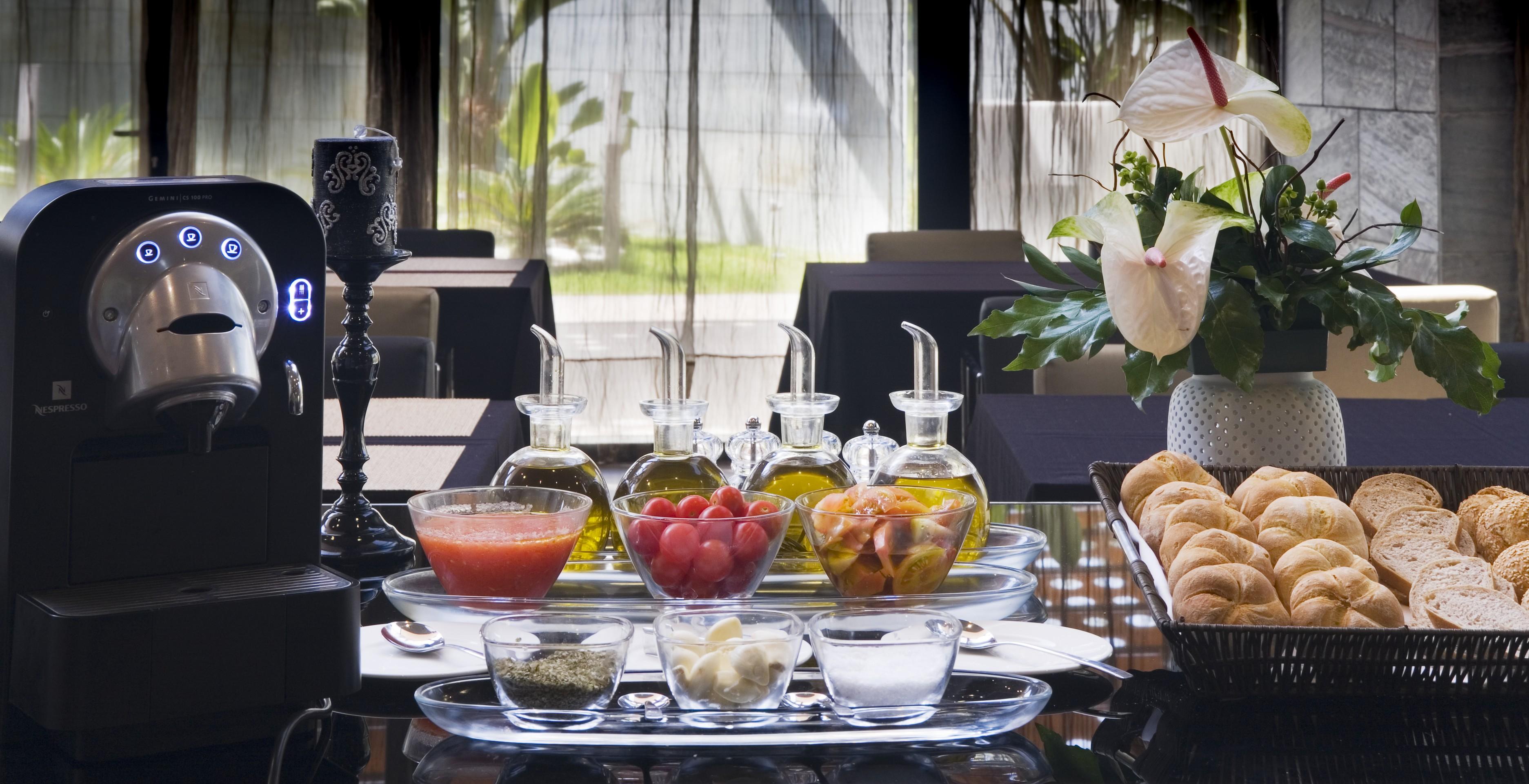Eurostars Palace Κόρδοβα Εξωτερικό φωτογραφία The photo showcases a beautifully arranged dining setting. In the center, there are several glass containers filled with different types of oils, possibly olive oil. Accompanying them are small bowls containing various ingredients, including what app