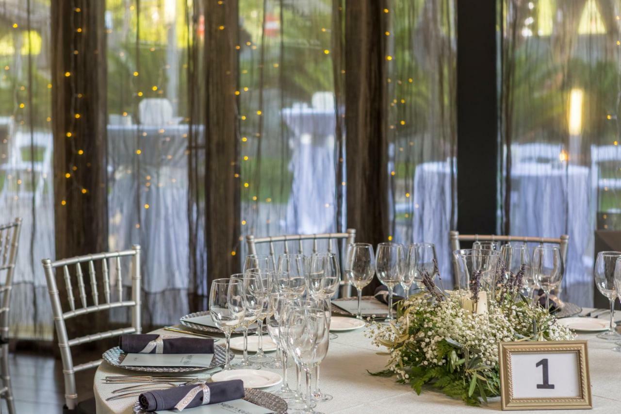 Eurostars Palace Κόρδοβα Εξωτερικό φωτογραφία The photo shows a beautifully set dining table in an elegant event space. The table is round, covered with a white tablecloth, and adorned with a centerpiece of greenery and flowers. There are several wine glasses and water glasses arranged neatly on